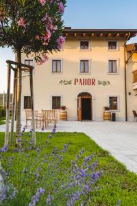 a building with purple flowers in front of it at Hotel & Restaurant Pahor in Doberdò del Lago