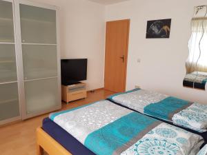 a bedroom with a bed and a flat screen tv at Ferienwohnung Jansen in Kirchhundem