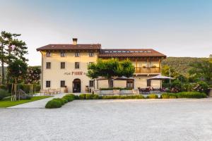 a large house with a driveway in front of it at Hotel & Restaurant Pahor in Doberdò del Lago