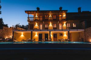 a building with a pool in front of it at night at Hotel & Restaurant Pahor in Doberdò del Lago +26 photos