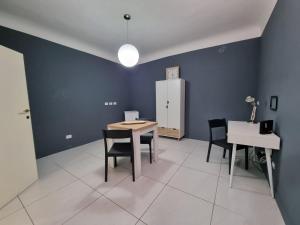 um quarto com uma mesa e cadeiras e um frigorífico em Amica Taranto em Taranto