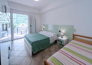 聖貝內代托德爾特龍托的住宿－Residence Dolcemare，一间卧室设有两张床和大窗户
