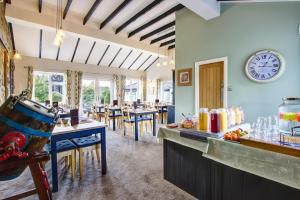 a dining room with a counter and a clock on the wall at Butterchurn Guest House in Otterburn
