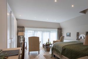 ein Schlafzimmer mit einem Bett und einem Stuhl in einem Zimmer in der Unterkunft B&B Huiskamer van Vollenhove in Vollenhove