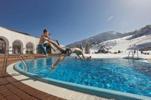 two young boys jumping into a swimming pool at Ferienhaus Michael in Bad Kleinkirchheim