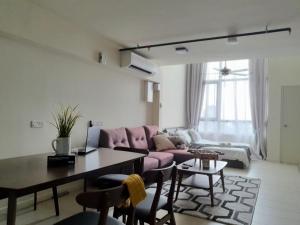 sala de estar con sofá rosa y mesa en The Perfect Getaway @ Tamarind Suites, Netflix 300Mbps, en Cyberjaya