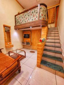 a living room with a staircase and a television at New Jaganmohana Comforts in Mysore