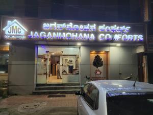 samochód zaparkowany w nocy przed sklepem w obiekcie New Jaganmohana Comforts w mieście Mysuru