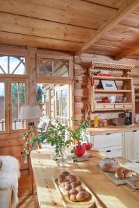 a wooden kitchen with a table with bread on it at Hruby Gazda - zabytkowa willa góralska na wyłączność in Bukowina Tatrzańska