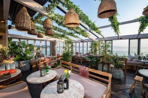 um restaurante com mesas, cadeiras e plantas em Mumbles Apartment near to shops and beach em The Mumbles