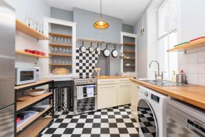 a kitchen with black and white checkered floor at Stylish 2 Bedroom Converted Victorian Storefront in London