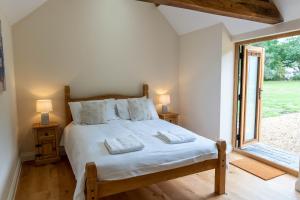 a bedroom with a bed and a large window at Lovely 1-bed suite & bathroom in converted barn near Newark Show-Ground 