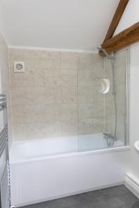 a shower with a glass door in a bathroom at Lovely 1-bed suite & bathroom in converted barn near Newark Show-Ground 