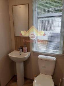 uma casa de banho com um WC, um lavatório e um espelho. em Trekker's Rest, Brigham, Cockermouth, Cumbria em Cockermouth