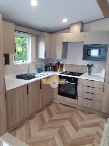 a kitchen with a sink and a stove top oven at Trekkers Rest, Brigham, Cockermouth, Cumbria in Cockermouth
