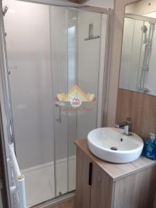 a bathroom with a sink and a glass shower at Trekker's Rest, Brigham, Cockermouth, Cumbria in Cockermouth