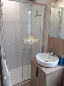 a bathroom with a sink and a glass shower at Trekkers Rest, Brigham, Cockermouth, Cumbria in Cockermouth