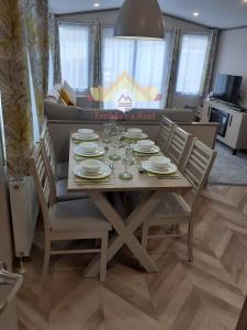 a table with plates and glasses on it in a living room at Trekker's Rest, Brigham, Cockermouth, Cumbria in Cockermouth