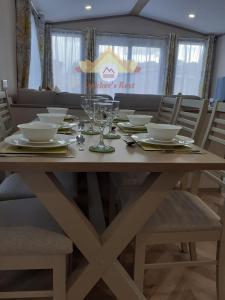 a dining room table with plates and glasses on it at Trekker's Rest, Brigham, Cockermouth, Cumbria in Cockermouth