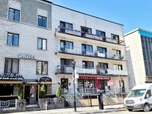 モントリオールにあるAPARTMENT HOTEL ST-DENISの正面に停車する車の通り沿いの建物