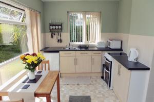 uma cozinha com uma mesa, um lavatório e uma janela em Abbey View Holiday Flats em Torquay