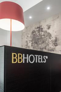 a black sign with a red lamp and a sign with the bbluds at BB Hotels Smarthotel Duomo in Milan