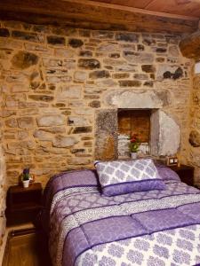 1 dormitorio con 1 cama en una pared de piedra en CASA PESCA VERA, en Senegüé