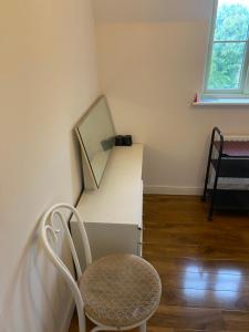 a room with a chair and a desk with a mirror at Cotswolds house in Cirencester