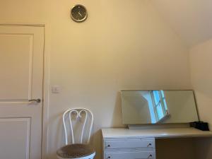 a room with a desk with a mirror and a clock at Cotswolds house in Cirencester