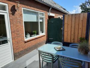 einen blauen Tisch und Stühle auf einer Terrasse in der Unterkunft Duinhuis26 in Egmond aan Zee