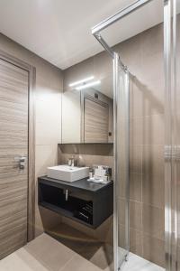 uma casa de banho com um lavatório e um chuveiro em BB Hotels Smarthotel Duomo em Milão
