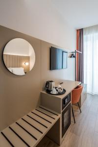 ein Hotelzimmer mit einem Tisch und einem Spiegel in der Unterkunft BB Hotels Smarthotel Duomo in Mailand