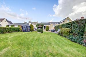 a large yard with a lawn in front of a house at Butterchurn Guest House in Otterburn