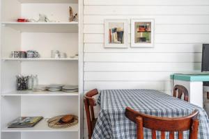 a dining room with a table and a shelf with dishes at Nautilus B&B in Pinamar