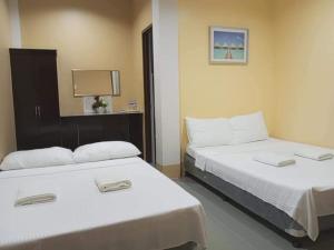 2 Betten in einem Hotelzimmer mit 2 Betten in der Unterkunft EL SUEÑO RESORT in Dauin