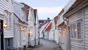 an alley with white houses and street lights at Apartment with two bedrooms and parking in Stavanger