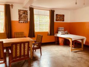 uma sala de jantar com paredes cor de laranja e uma mesa e cadeiras em Yes Hostel em Fort Portal
