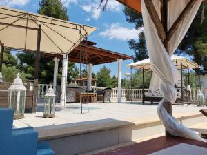 a patio with umbrellas and tables and chairs at Villa Askamnia and Suites in Nikiti