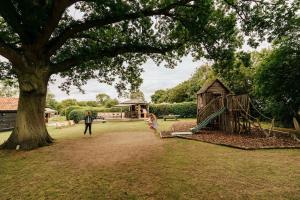 a man and a child playing in a park with a playground at Beautiful Cottage in Bredfield near to Woodbridge on the Suffolk Coast in Bredfield