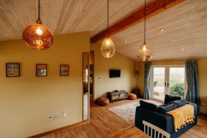 a living room with a couch and pendant lights at Beautiful Cottage in Bredfield near to Woodbridge on the Suffolk Coast in Bredfield