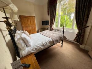 a bedroom with a bed and a large window at Broughton Craggs Hotel in Cockermouth