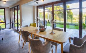 a dining room with a wooden table and chairs at MOUNTAIN HILL LUXURY VILLA in Madzhare
