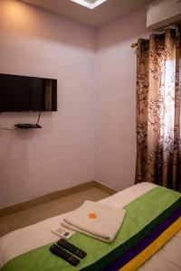 a room with a bed with a flat screen tv on the wall at Hotel City View INN in Guwahati