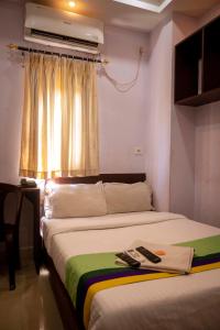 two beds in a room with two remote controls at Hotel City View INN in Guwahati