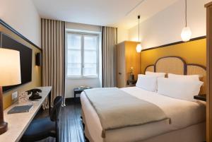 パリにあるザ チェス ホテルのベッドとデスクが備わるホテルルームです。