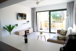 un salon avec une bouteille de vin sur une table dans l'établissement Oeste Tere by Best Holidays Fuerteventura, à Corralejo