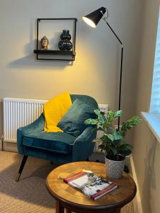 a living room with a green chair and a table at Beautiful 2 bedroom townhouse. in Darlington