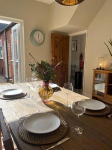 a dining room table with plates and wine glasses at Beautiful 2 bedroom townhouse. in Darlington