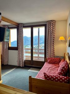 een slaapkamer met een bed en een groot raam bij RISOUL - Résidence ALTAIR - 5 couchages - À 1min à pieds des pistes in Risoul