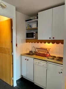 een keuken met witte kasten en een aanrecht bij RISOUL - Résidence ALTAIR - 5 couchages - À 1min à pieds des pistes in Risoul